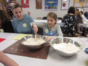 mother and daughter mixing dry ingredients in a bowl